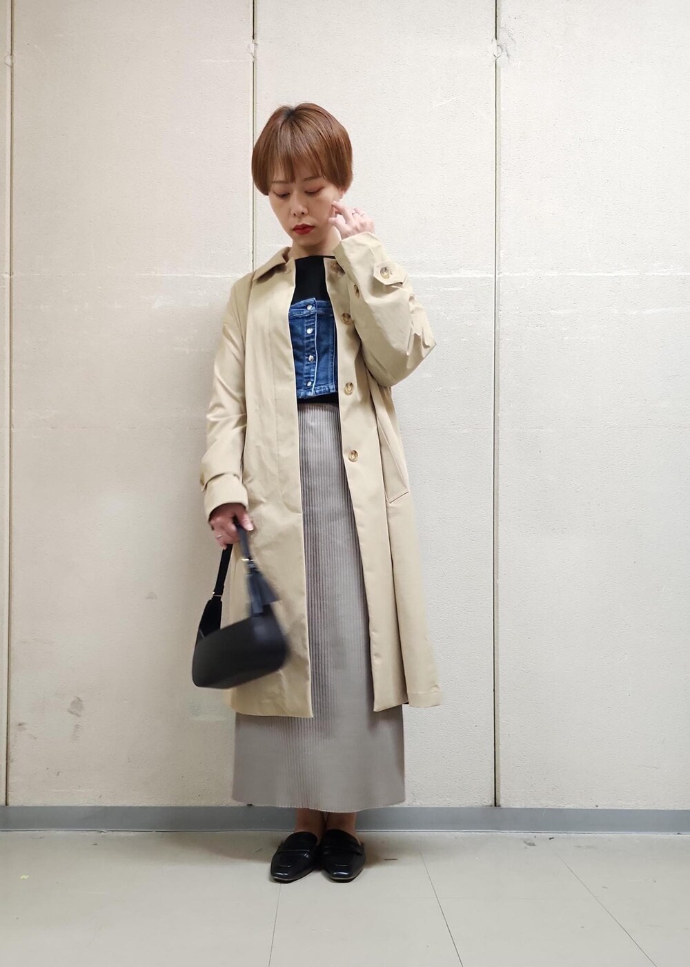 ブラック系のハンドバッグ、ブラウン系のスカート、ブラック系のTシャツ/カットソーを着用したレディースの春コーディネートの2枚目の写真