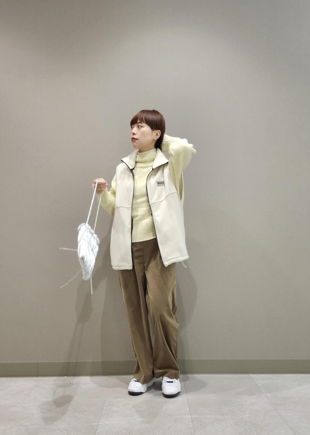 ホワイト系のニット/セーター、シルバー系のショルダーバッグ、ホワイト系のその他アウターを着用したレディースの冬コーディネートの4枚目の写真