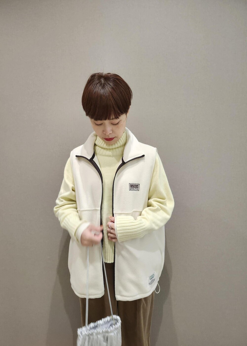 ホワイト系のニット/セーター、シルバー系のショルダーバッグ、ホワイト系のその他アウターを着用したレディースの冬コーディネートの8枚目の写真