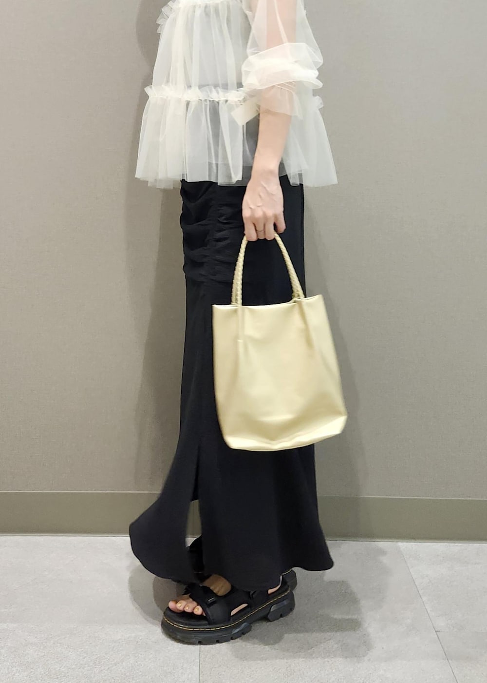 グレー系のタンクトップ、ホワイト系のカーディガン/ボレロ、ゴールド系のトートバッグを着用したレディースの夏コーディネートの10枚目の写真