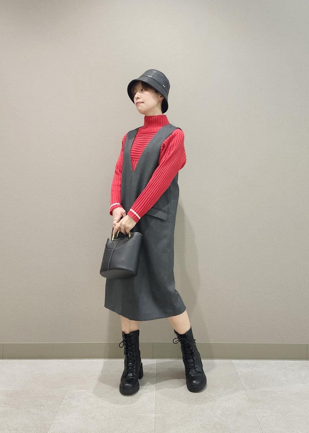 グレー系のジャンパースカート、ホワイト系のその他アウター、レッド系のニット/セーターを着用したレディースの秋コーディネートの8枚目の写真