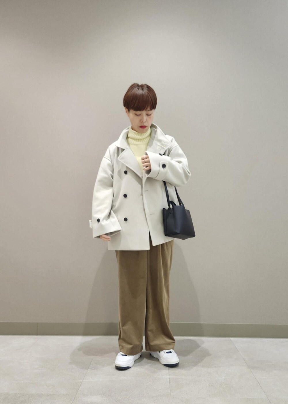 イエロー系のニット/セーター、ホワイト系のニット/セーター、ブラウン系のその他パンツを着用したレディースの冬コーディネートの5枚目の写真