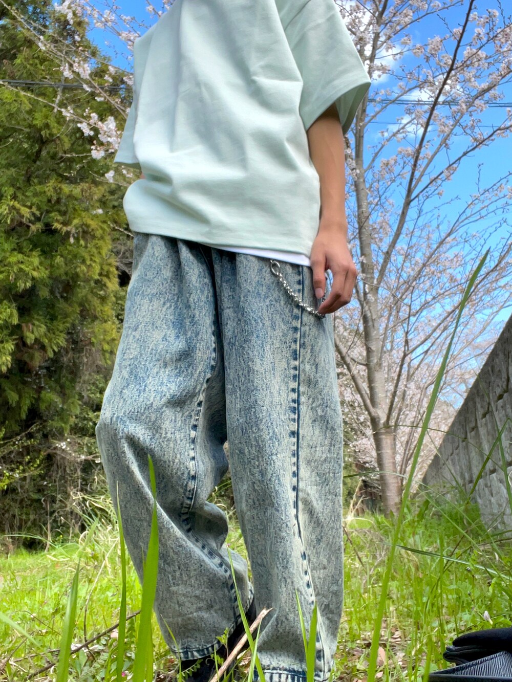 ブラック系のトートバッグ、ベージュ系のデニムパンツ、ブラック系のその他アウターを着用したメンズの春コーディネートの3枚目の写真
