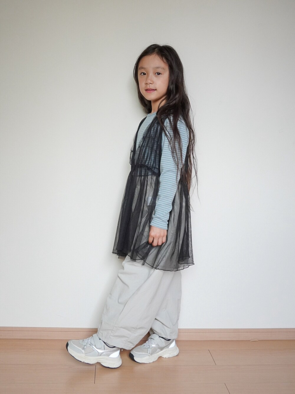 グレー系のその他パンツ、ブラック系のチュニック、ブルー系のTシャツ/カットソーを着用したキッズの秋コーディネートの2枚目の写真