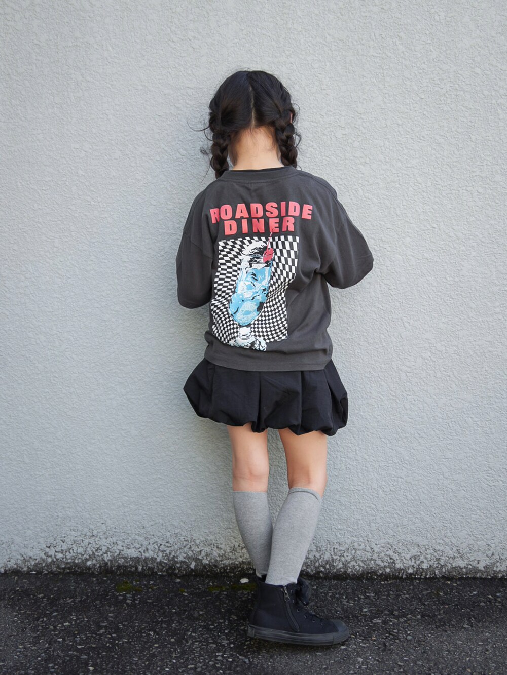 ブラック系のTシャツ/カットソー、ブラック系のスカート、ブラック系のスニーカーを着用したキッズの春コーディネートの4枚目の写真