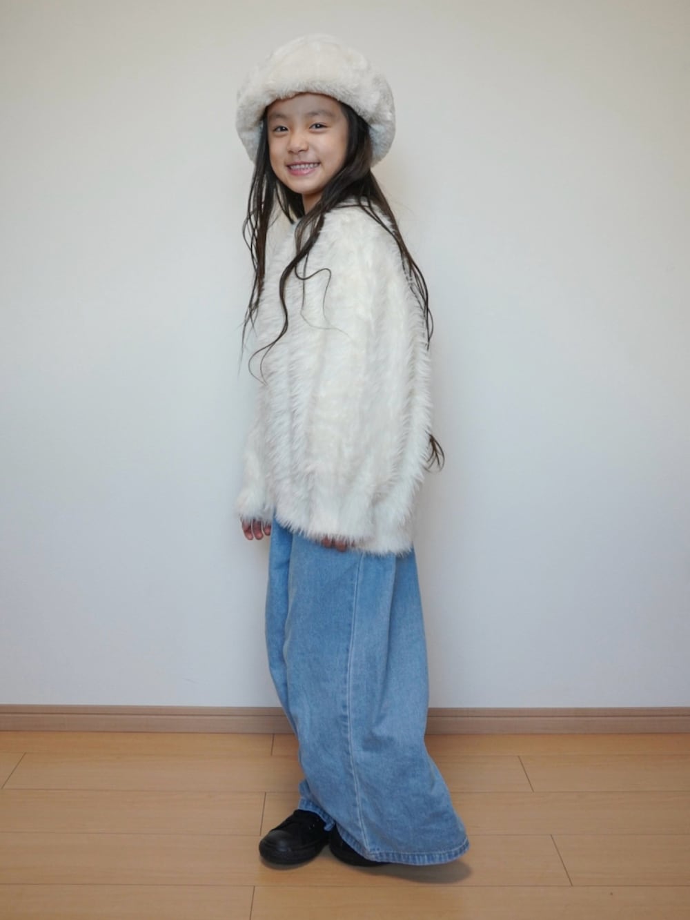 ホワイト系のニット/セーター、ブルー系のデニムパンツ、ブラック系のスニーカーを着用したキッズの冬コーディネートの2枚目の写真