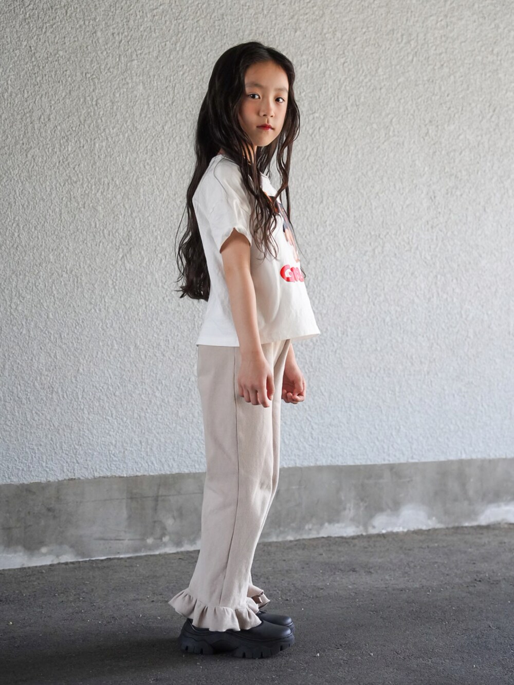 その他のTシャツ/カットソー、ベージュ系のその他パンツ、ブラック系のスニーカーを着用したキッズの春コーディネートの3枚目の写真