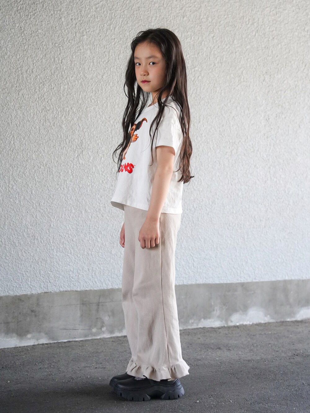 その他のTシャツ/カットソー、ベージュ系のその他パンツ、ブラック系のスニーカーを着用したキッズの春コーディネートの2枚目の写真