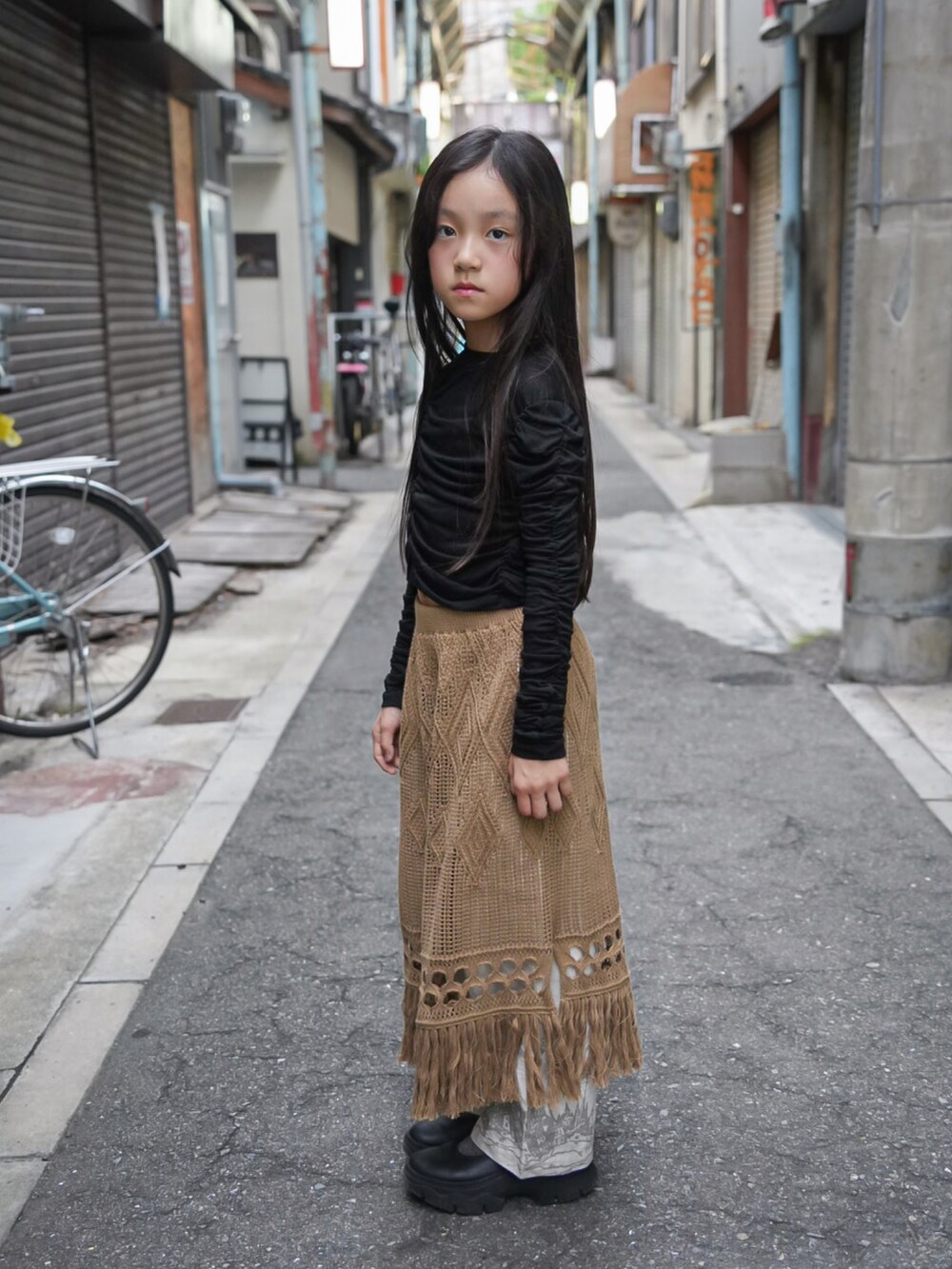 ブラック系のTシャツ/カットソー、ホワイト系のその他パンツ、ベージュ系のスカートを着用したキッズの秋コーディネートの2枚目の写真