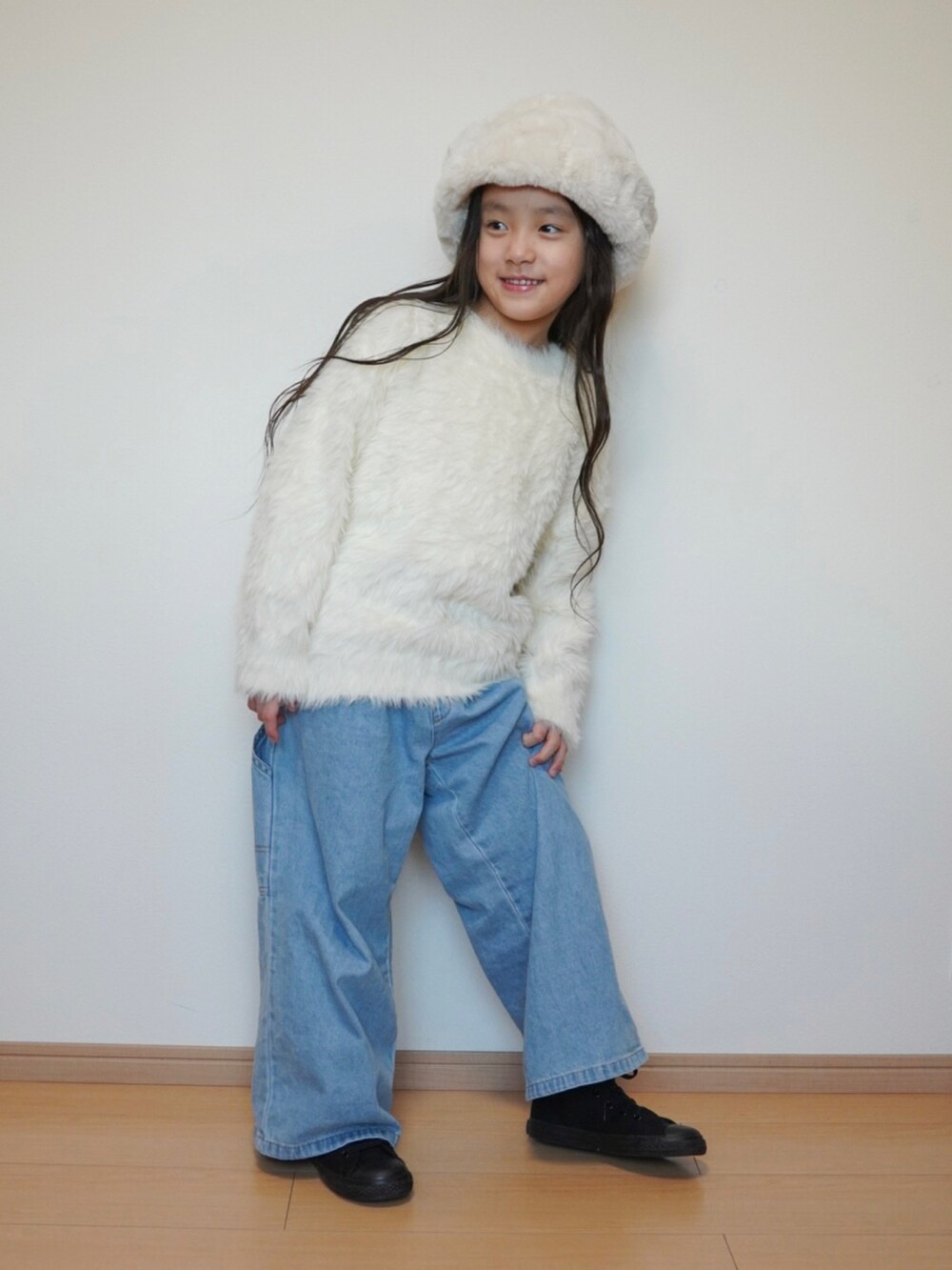 ホワイト系のニット/セーター、ブルー系のデニムパンツ、ブラック系のスニーカーを着用したキッズの冬コーディネートの3枚目の写真