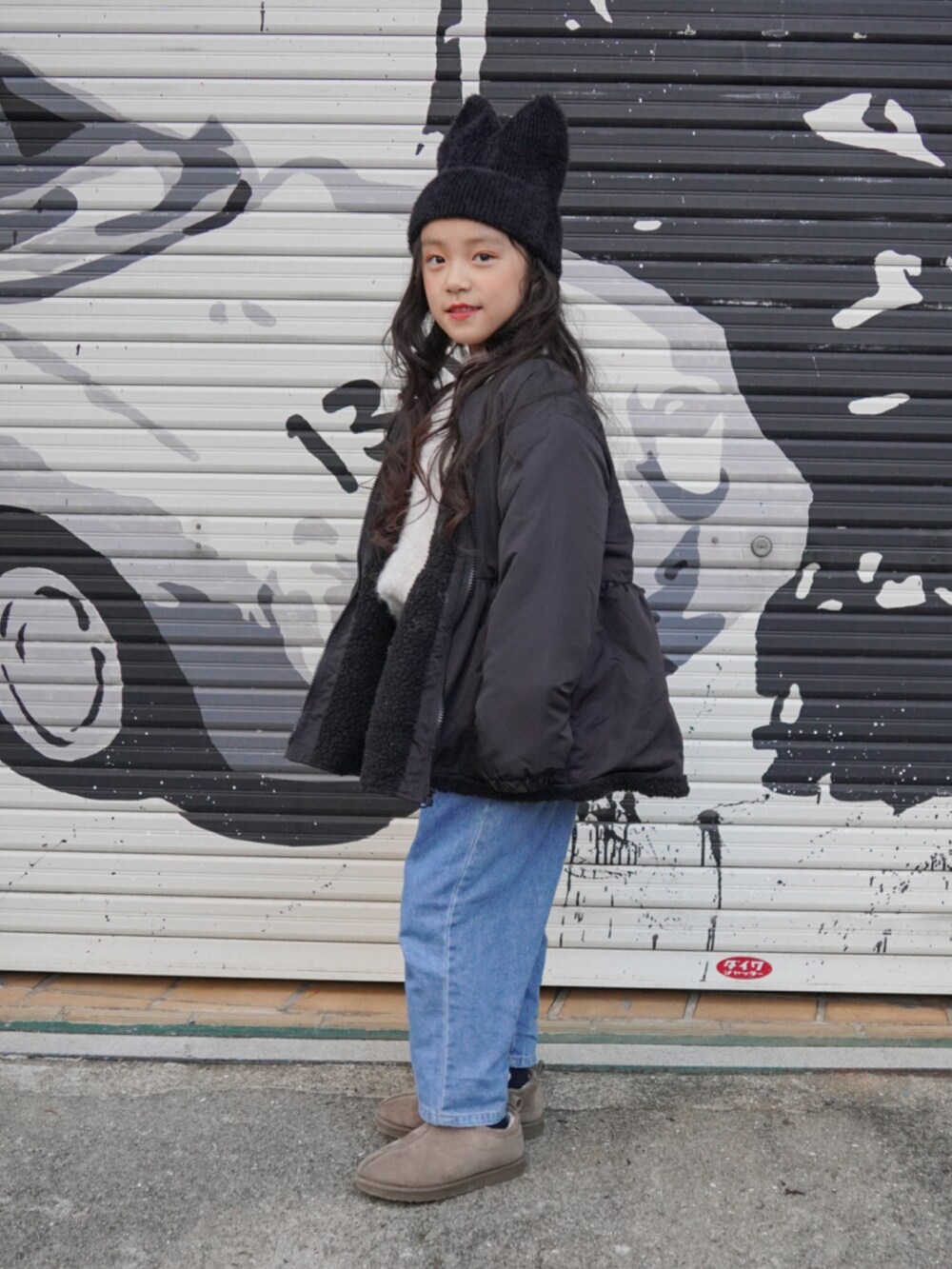 ブラック系のブルゾン、グレー系のブーツ、ブルー系のデニムパンツを着用したキッズの冬コーディネートの2枚目の写真