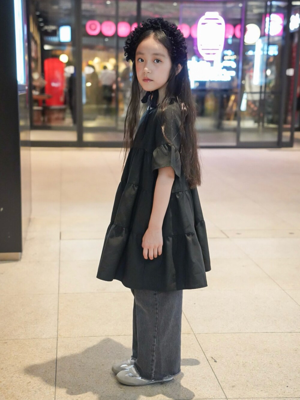 ブラック系のワンピース、その他のデニムパンツ、シルバー系のスニーカーを着用したキッズの夏コーディネートの2枚目の写真
