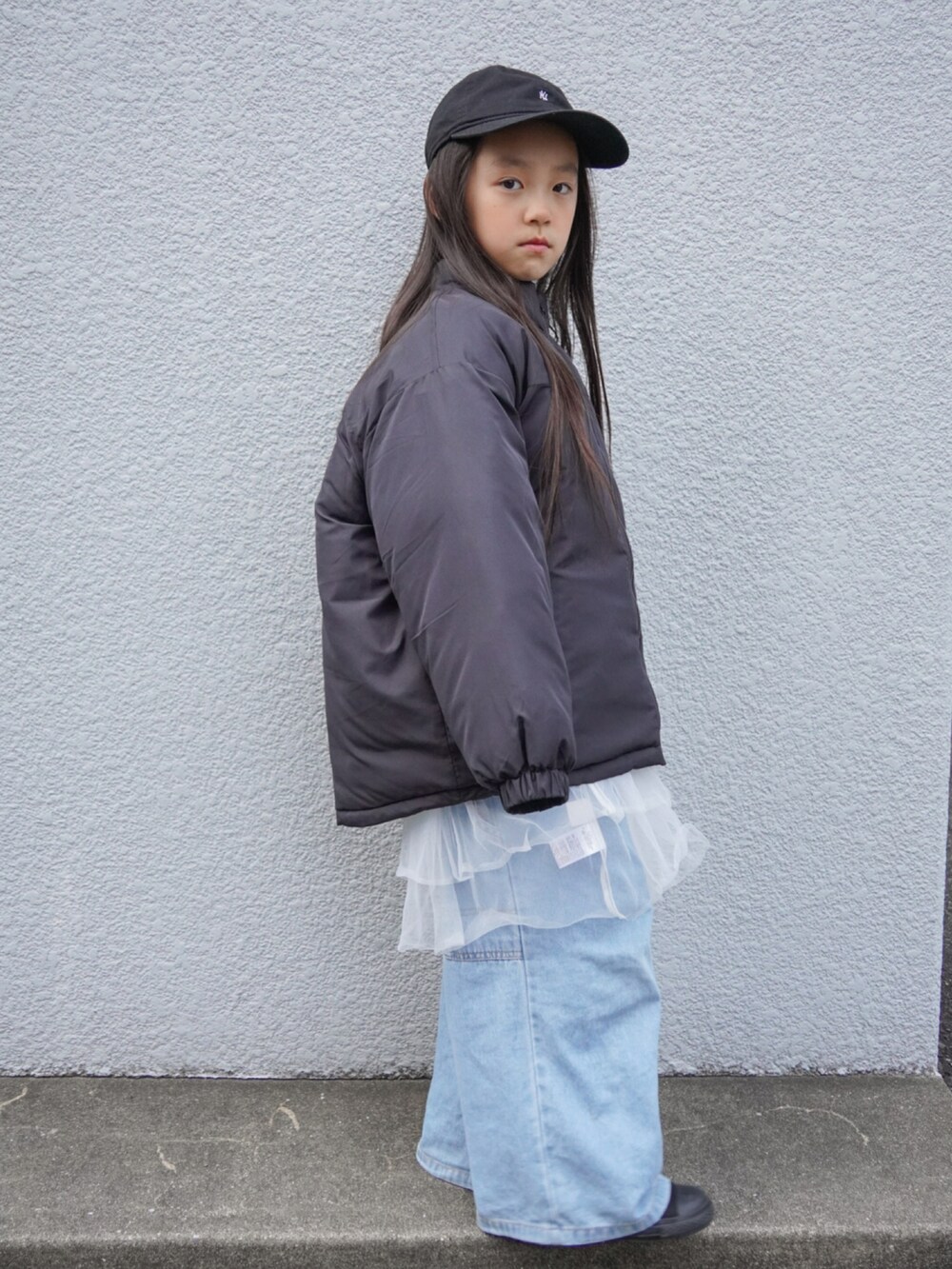 ブラック系のブルゾン、ブルー系のデニムパンツ、ブラック系のスニーカーを着用したキッズの冬コーディネートの3枚目の写真