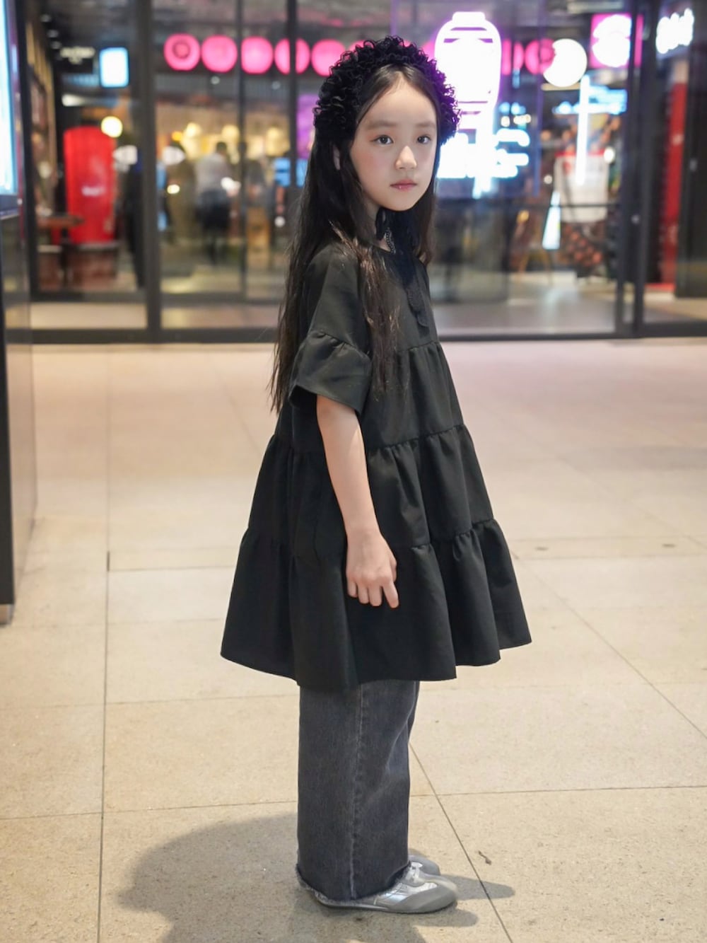 ブラック系のワンピース、その他のデニムパンツ、シルバー系のスニーカーを着用したキッズの夏コーディネートの3枚目の写真