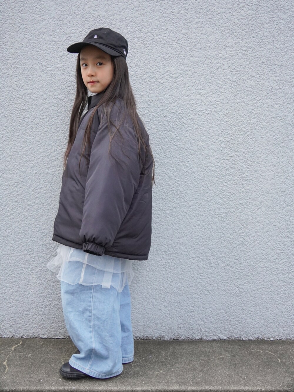 ブラック系のブルゾン、ブルー系のデニムパンツ、ブラック系のスニーカーを着用したキッズの冬コーディネートの2枚目の写真