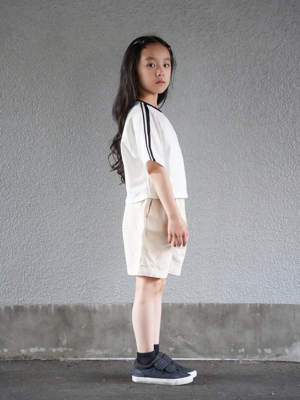 ホワイト系のTシャツ/カットソー、ホワイト系のその他パンツ、ブラック系のスニーカーを着用したキッズの春コーディネートの2枚目の写真