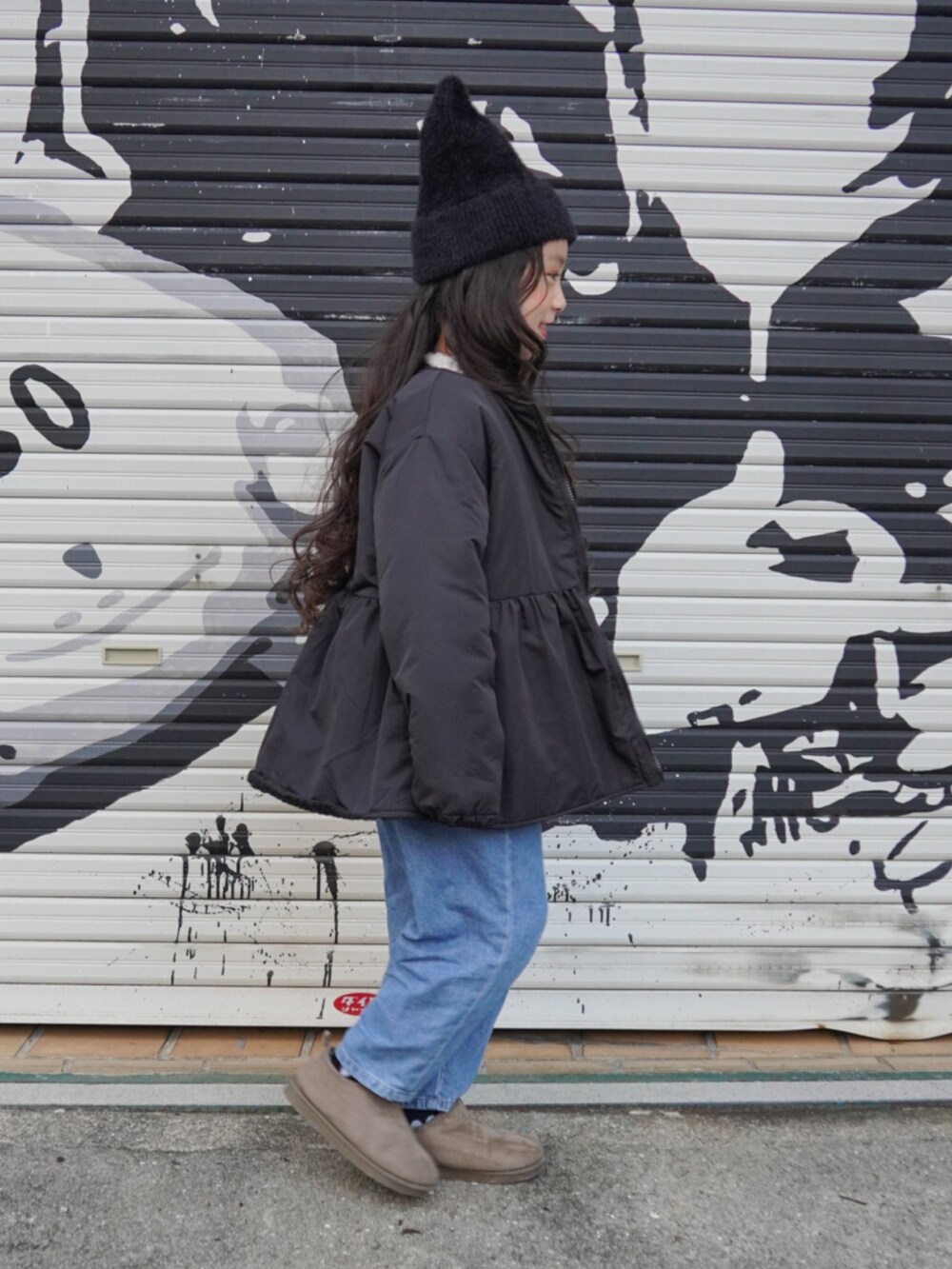 ブラック系のブルゾン、グレー系のブーツ、ブルー系のデニムパンツを着用したキッズの冬コーディネートの3枚目の写真