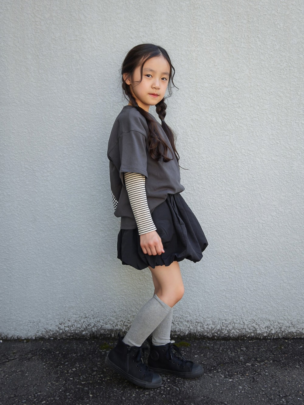 ブラック系のTシャツ/カットソー、ブラック系のスカート、ブラック系のスニーカーを着用したキッズの春コーディネートの3枚目の写真