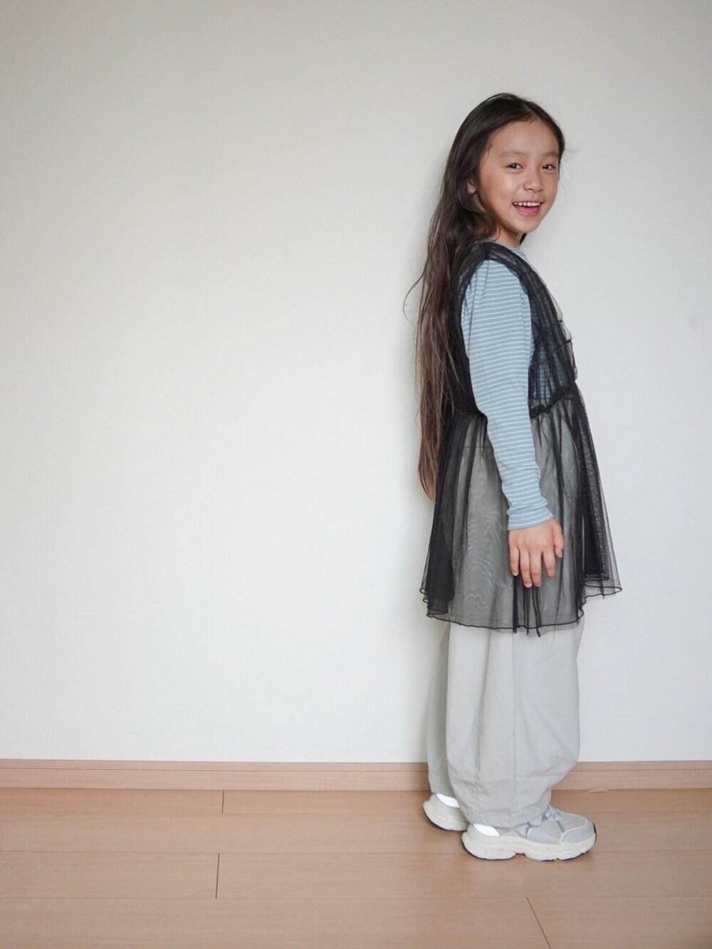 グレー系のその他パンツ、ブラック系のチュニック、ブルー系のTシャツ/カットソーを着用したキッズの秋コーディネートの3枚目の写真