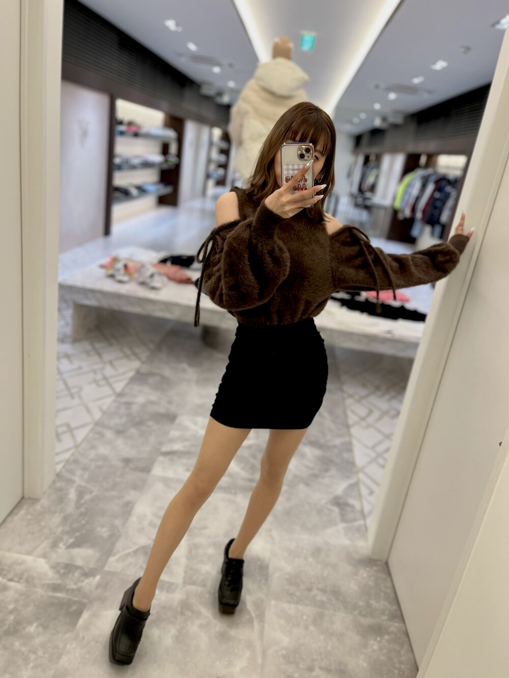 ベージュ系のトレンチコート、ブラック系のローファー、ブラウン系のニット/セーターを着用したレディースの秋コーディネートの2枚目の写真