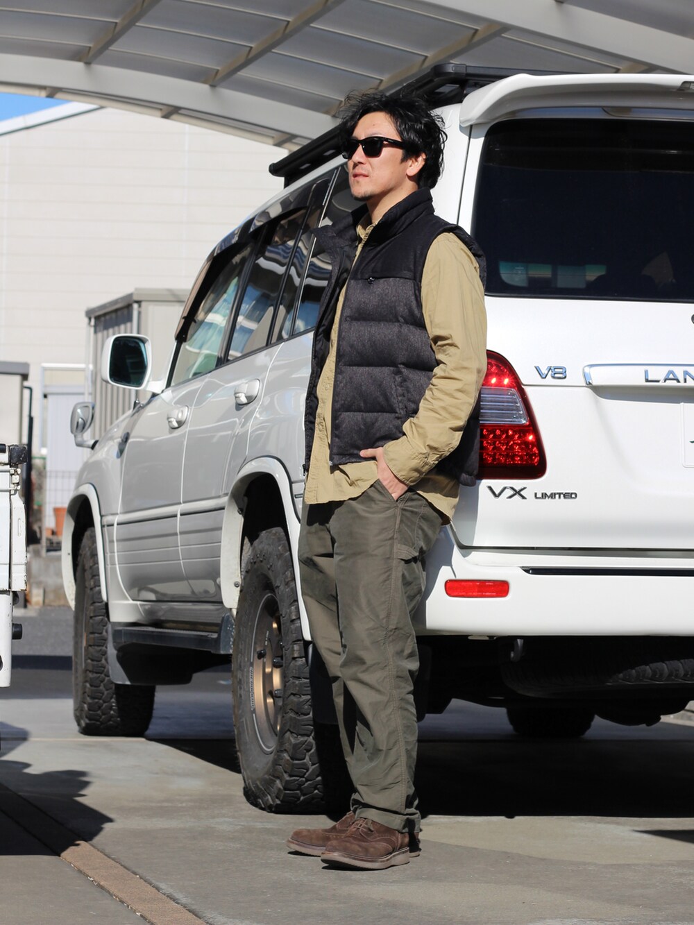 ブラック系のダウンベスト、グリーン系のその他パンツ、ブラウン系のシューズを着用したメンズの冬コーディネートの2枚目の写真