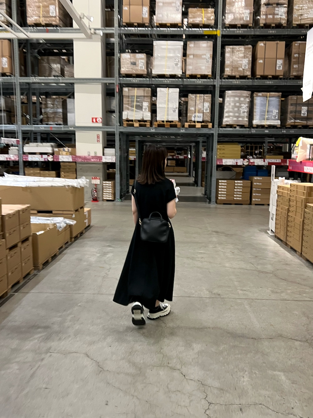 ブラック系のワンピース、ブラック系のショルダーバッグ、ブラック系のスニーカーを着用したレディースの夏コーディネートの2枚目の写真