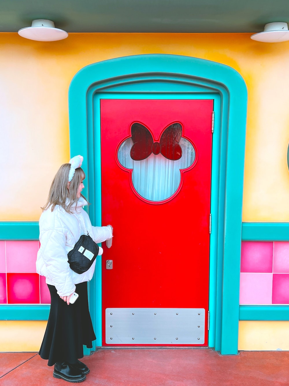 ブラック系のスカート、ブラック系のブーツ、ブラック系のショルダーバッグを着用したレディースの冬コーディネートの2枚目の写真