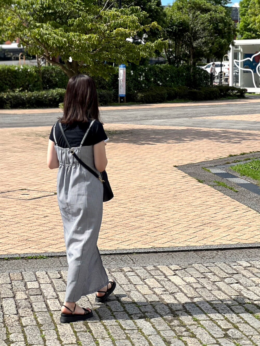 ブラック系のTシャツ/カットソー、ブラック系のショルダーバッグ、その他のワンピースを着用したレディースの夏コーディネートの2枚目の写真