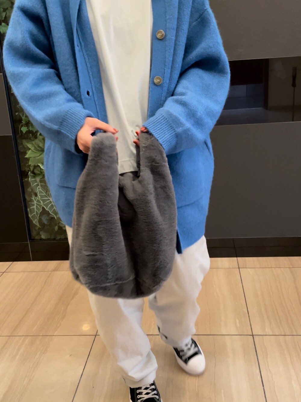 ブルー系のカーディガン/ボレロ、ホワイト系のTシャツ/カットソー、ブラック系のトートバッグを着用したレディースの秋コーディネートの2枚目の写真