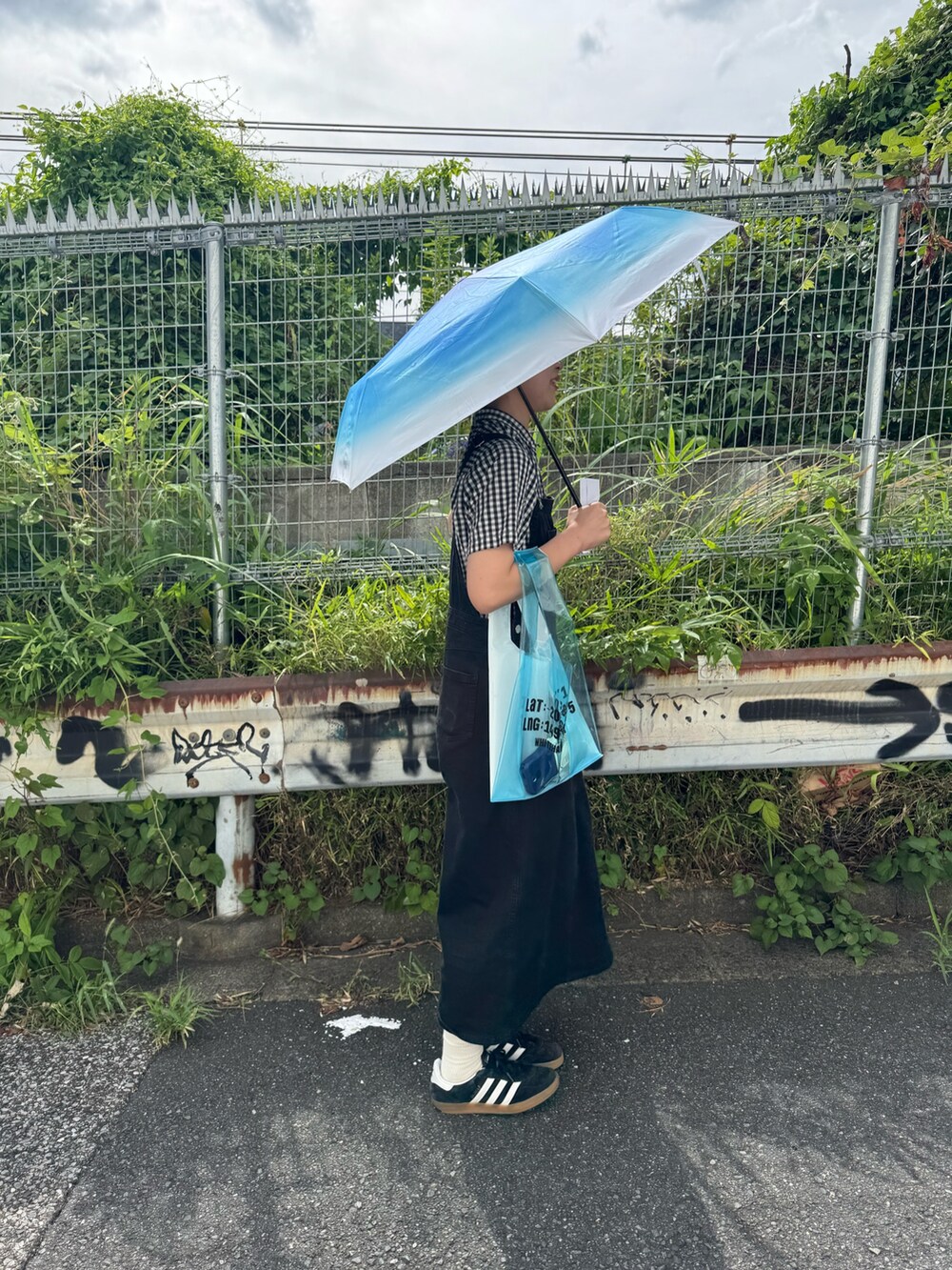 ブルー系のトートバッグ、ブルー系の折りたたみ傘を着用したレディースの夏コーディネートの2枚目の写真