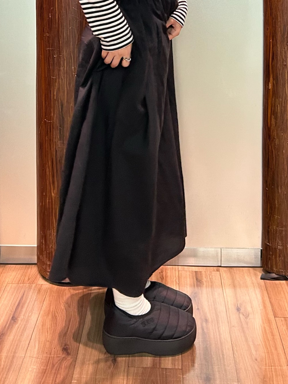 ブラック系のサンダルを着用したレディースの秋コーディネートの2枚目の写真