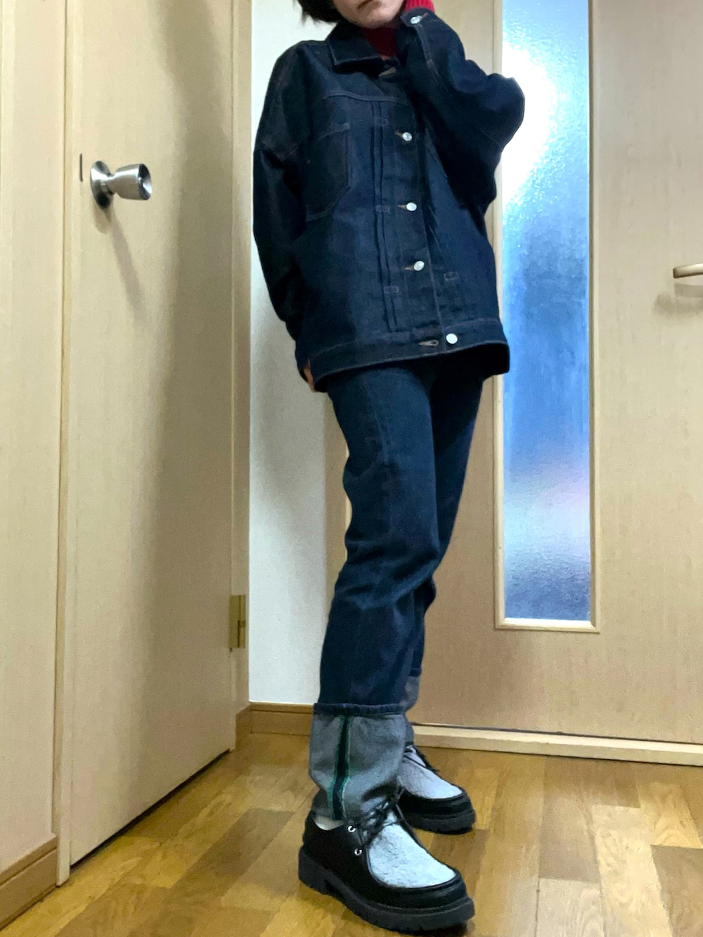 ブルー系のデニムパンツ、ブルー系のデニムジャケット、レッド系のニット/セーターを着用したレディースの春コーディネートの2枚目の写真