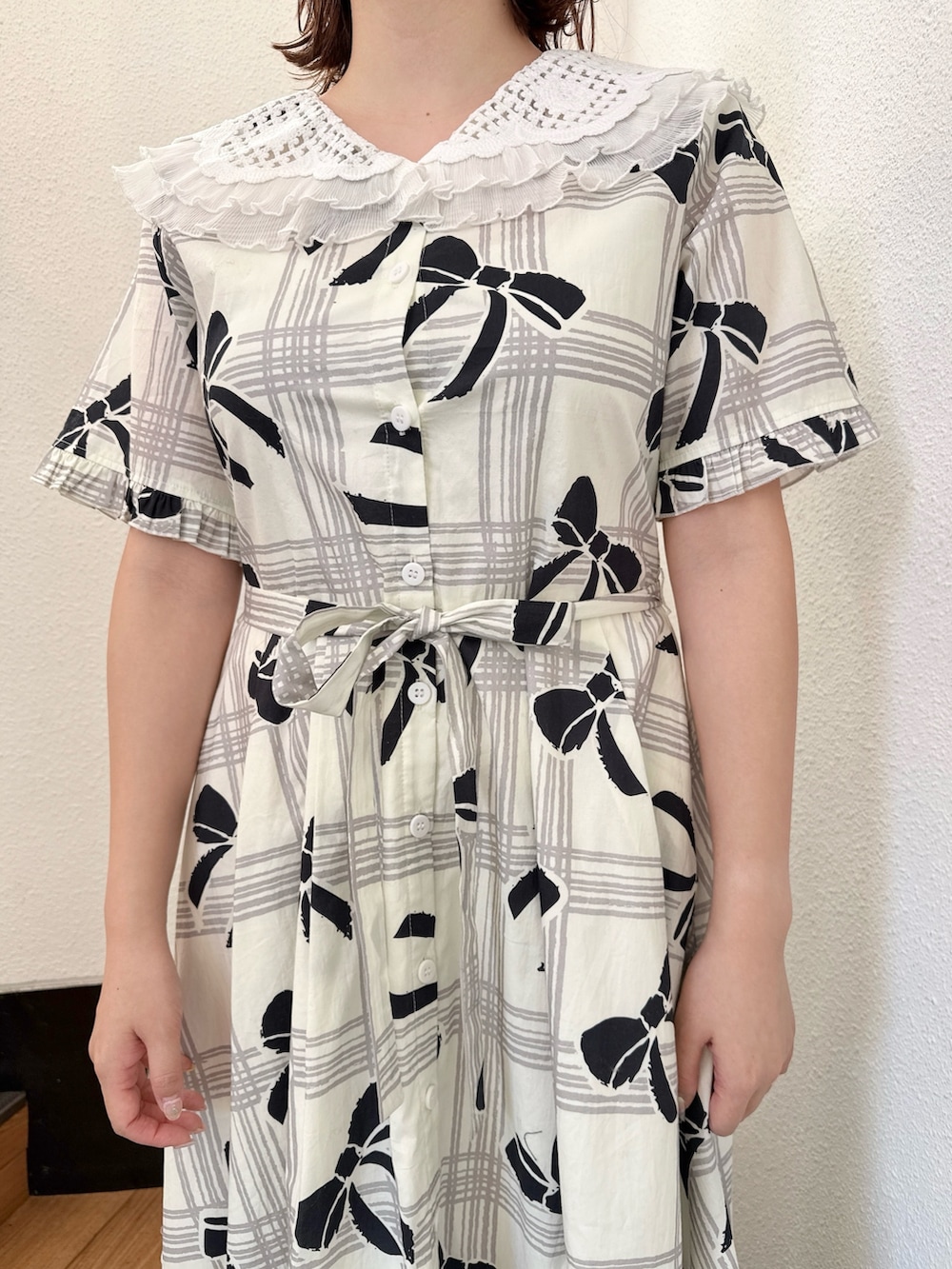 ホワイト系のワンピース、ブラック系のスニーカーを着用したレディースの冬コーディネートの6枚目の写真