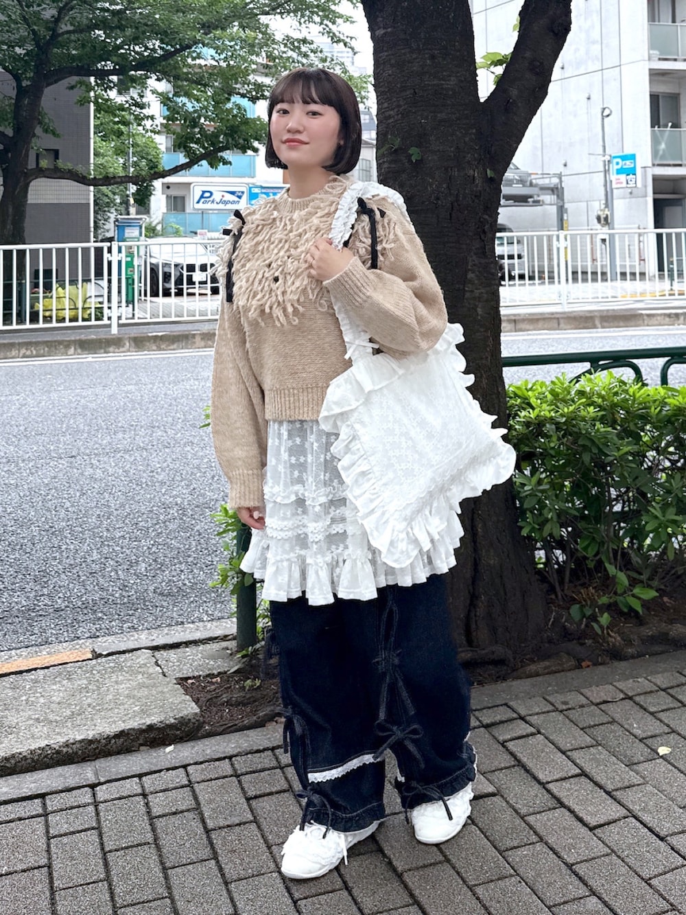 ブルー系のデニムパンツ、ホワイト系のスニーカー、ホワイト系のスカートを着用したレディースの夏コーディネートの2枚目の写真