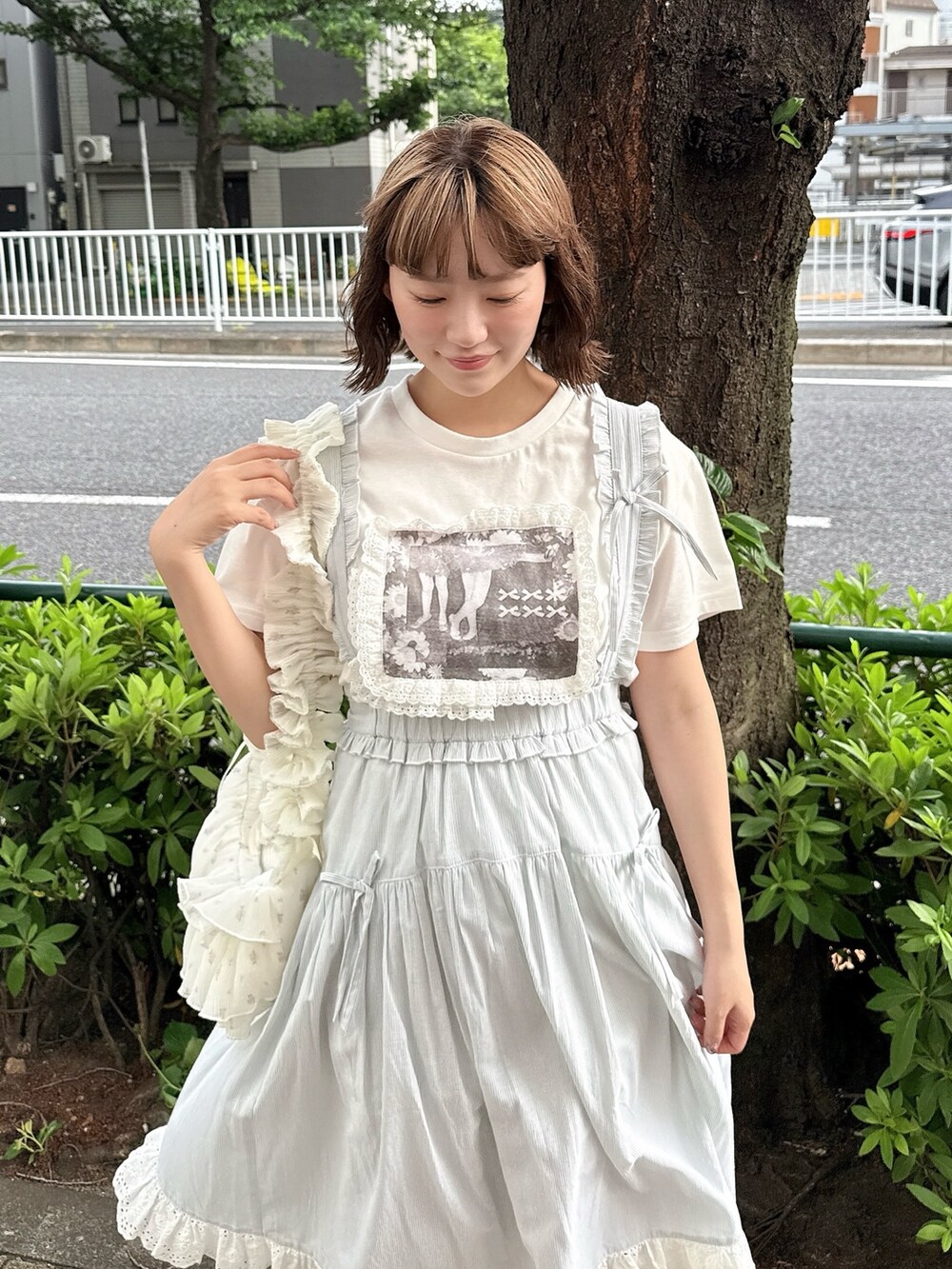 ホワイト系のTシャツ/カットソー、グリーン系のジャンパースカート、ホワイト系のショルダーバッグを着用したレディースの春コーディネートの4枚目の写真