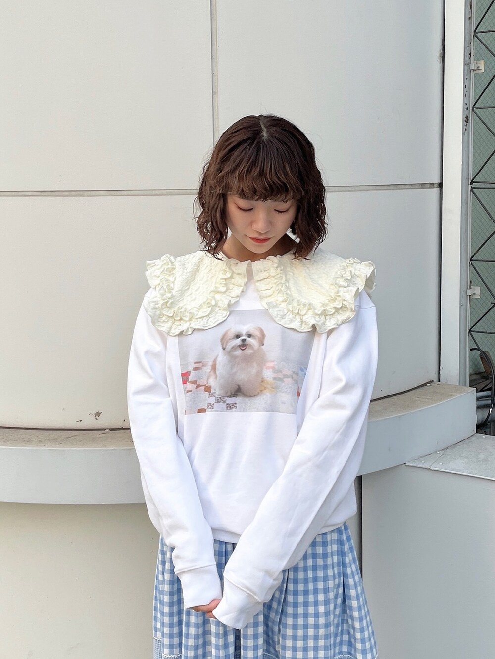 ホワイト系のスウェット、ホワイト系のTシャツ/カットソー、ブルー系のスカートを着用したレディースの冬コーディネートの4枚目の写真