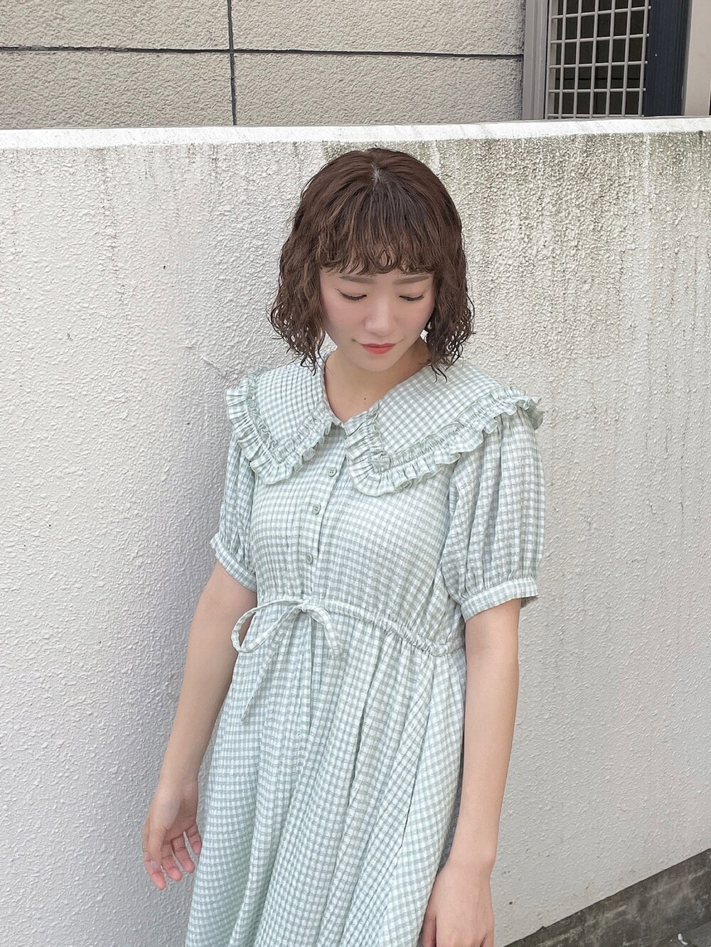 グリーン系のワンピース、ホワイト系のトートバッグ、ホワイト系のサンダルを着用したレディースの春コーディネートの6枚目の写真