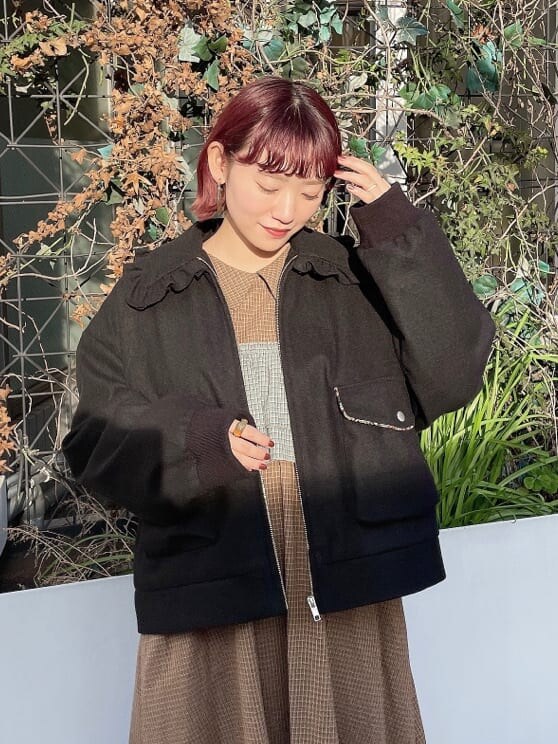 ホワイト系のブーツ、ブラック系のブルゾン、グリーン系のワンピースを着用したレディースの冬コーディネートの5枚目の写真