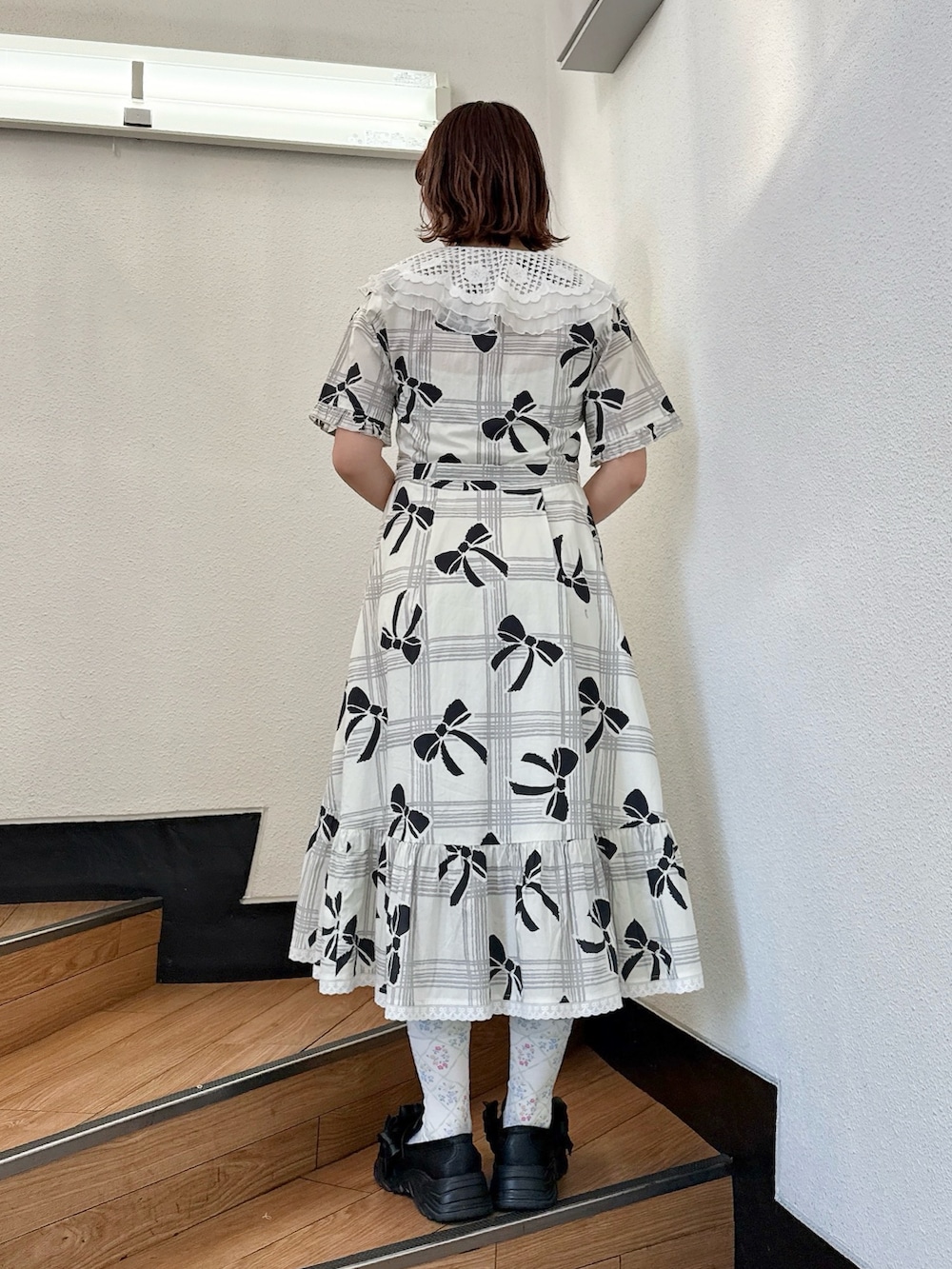 ホワイト系のワンピース、ブラック系のスニーカーを着用したレディースの冬コーディネートの3枚目の写真