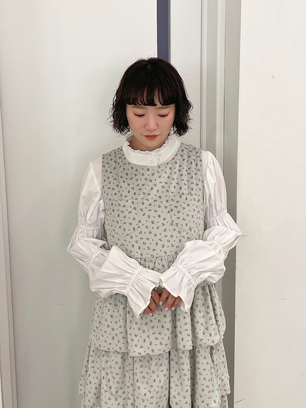 ホワイト系のシャツ/ブラウス、グリーン系のジャンパースカート、ホワイト系のブーツを着用したレディースの秋コーディネートの3枚目の写真