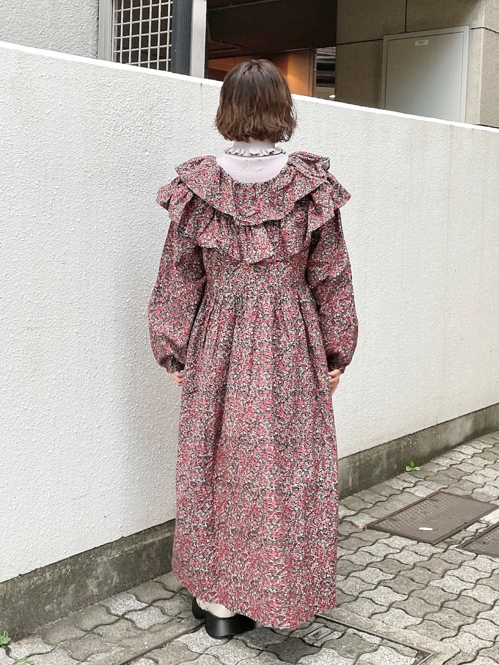 ピンク系のワンピース、パープル系のニット/セーター、ホワイト系のブーツを着用したレディースの秋コーディネートの3枚目の写真