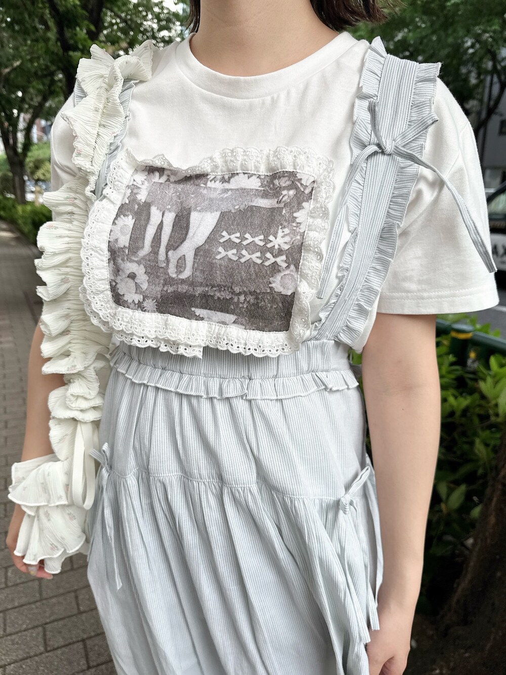 ホワイト系のTシャツ/カットソー、グリーン系のジャンパースカート、ホワイト系のショルダーバッグを着用したレディースの春コーディネートの6枚目の写真