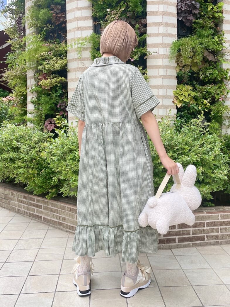 グリーン系のワンピース、ホワイト系のスニーカー、ホワイト系のハンドバッグを着用したレディースの夏コーディネートの2枚目の写真