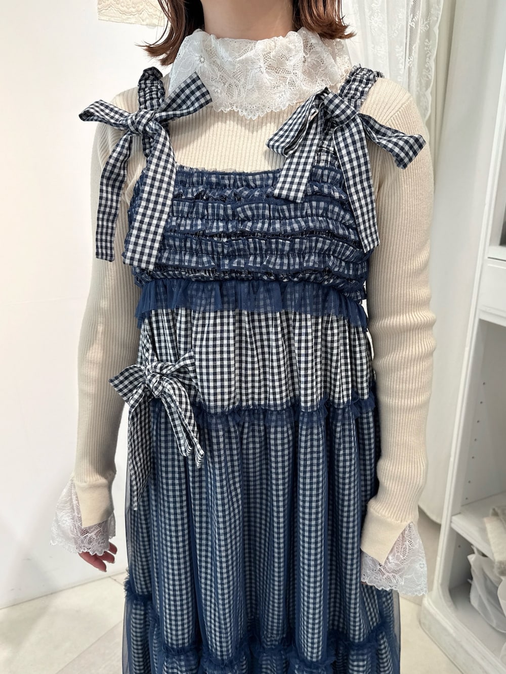 ホワイト系のニット/セーター、ブルー系のワンピース、ホワイト系のローファーを着用したレディースの冬コーディネートの4枚目の写真