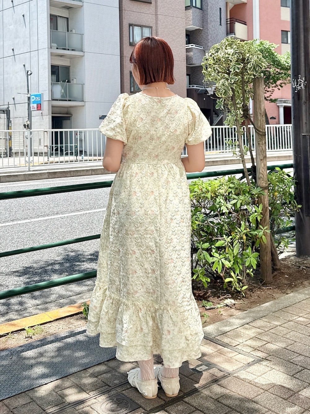 ブラウン系のハンドバッグ、イエロー系のワンピース、ホワイト系のバレエシューズを着用したレディースの春コーディネートの3枚目の写真