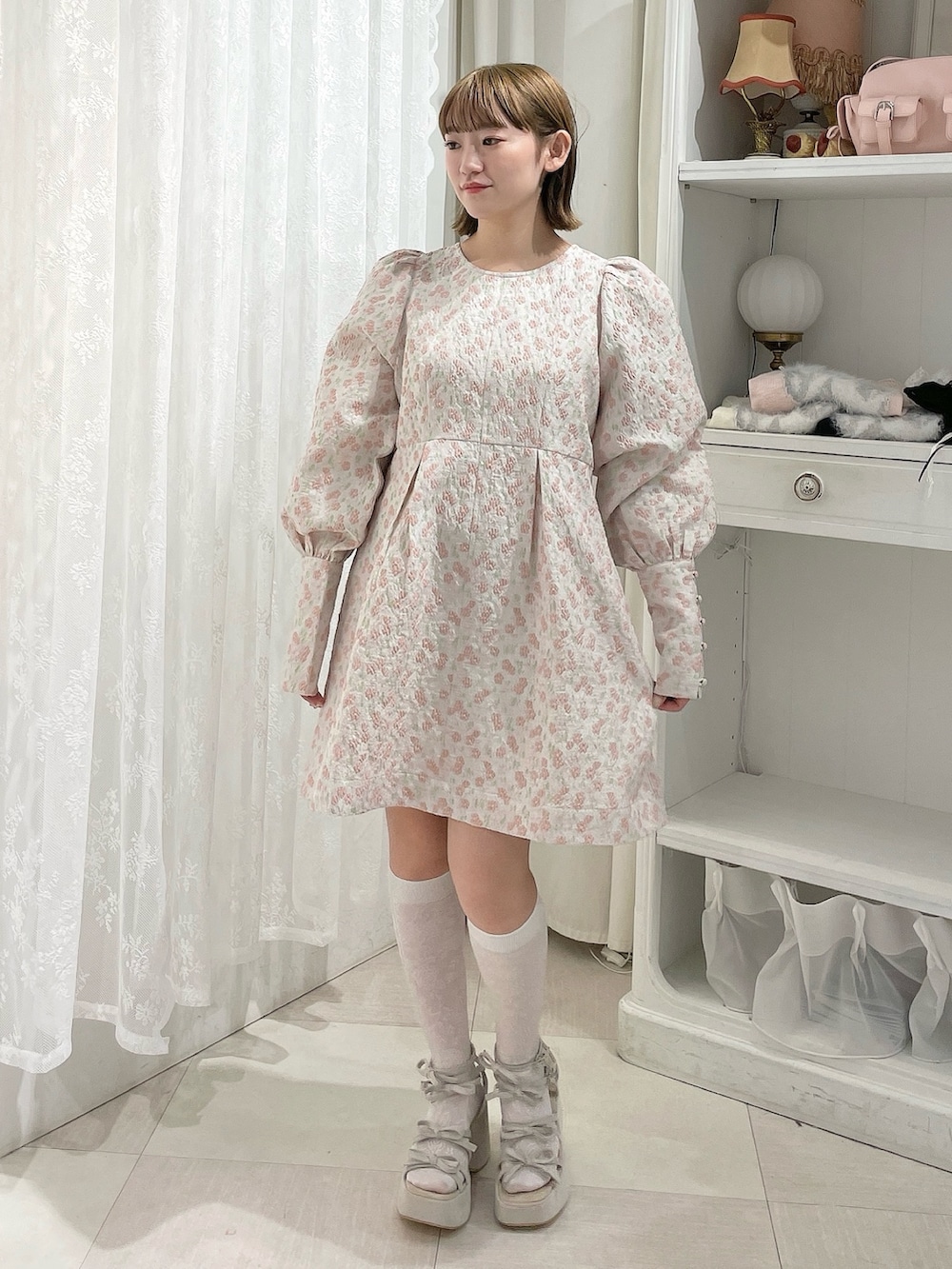 ピンク系のワンピース、ベージュ系のサンダルを着用したレディースの冬コーディネートの2枚目の写真