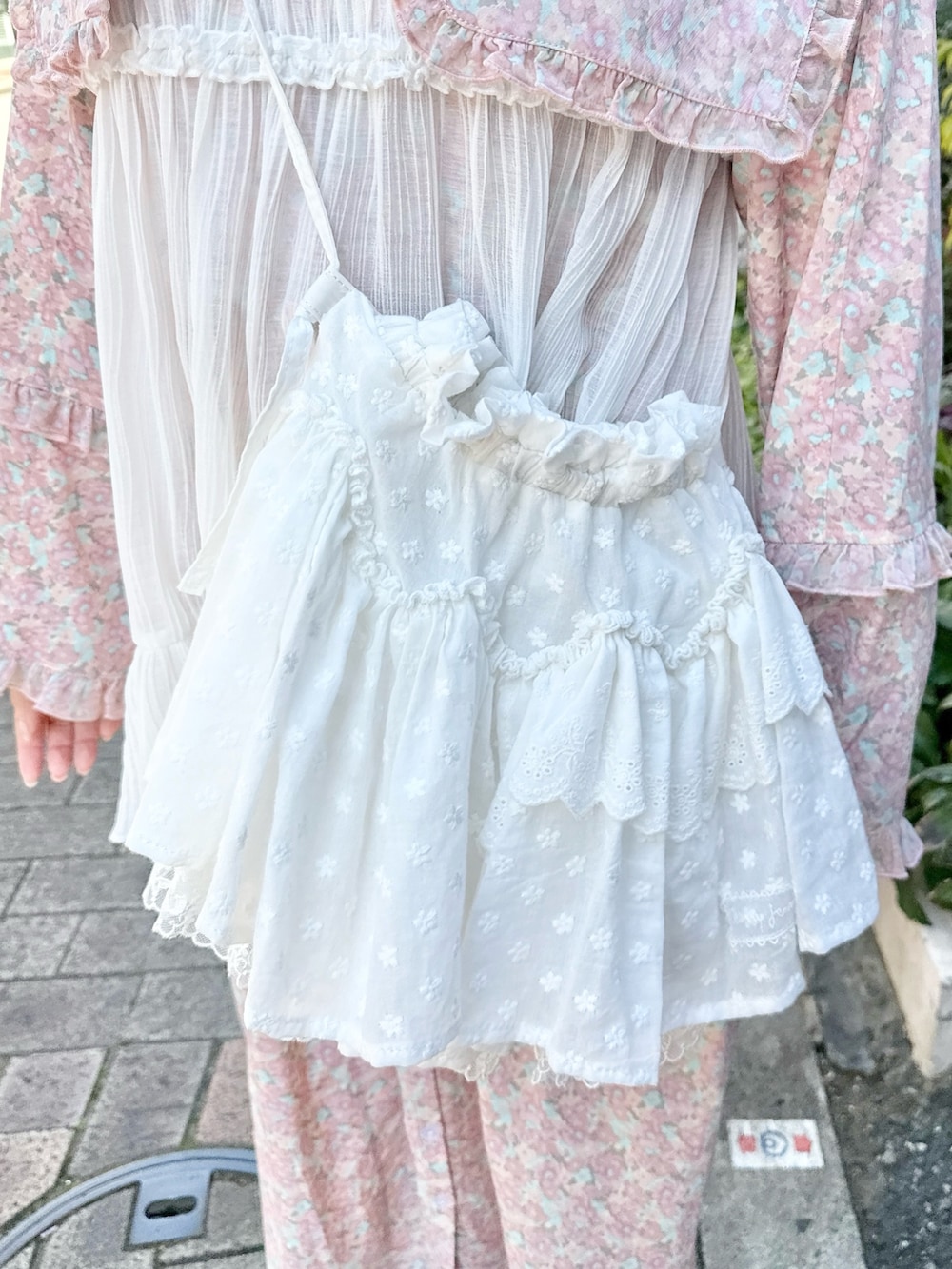 ピンク系のワンピース、ホワイト系のショルダーバッグ、ホワイト系のチュニックを着用したレディースの冬コーディネートの6枚目の写真