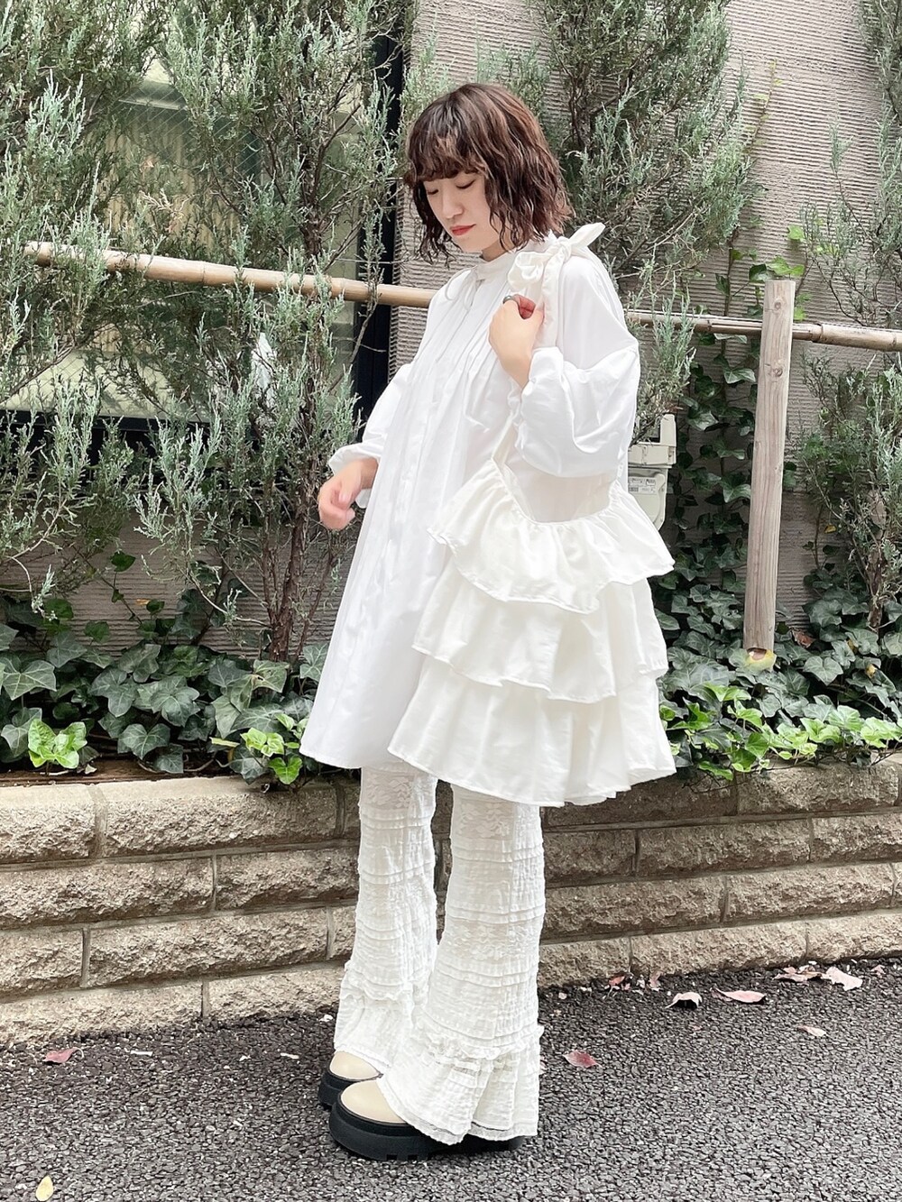 ホワイト系のワンピース、ホワイト系のスラックス、ベージュ系のブーツを着用したレディースの冬コーディネートの3枚目の写真