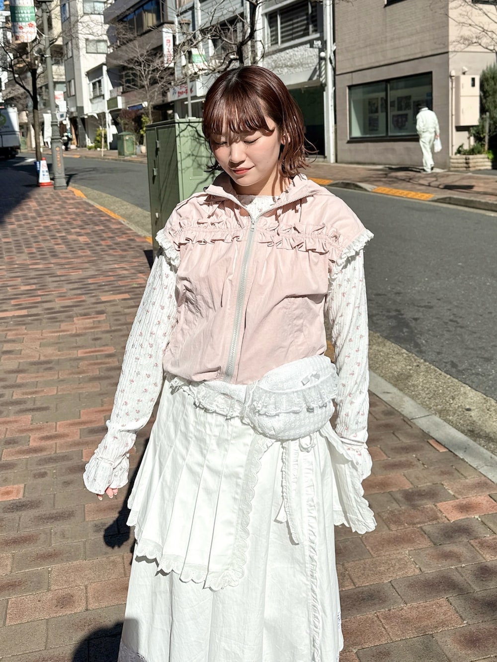 ピンク系のベスト、ピンク系のTシャツ/カットソー、ホワイト系のスカートを着用したレディースの春コーディネートの4枚目の写真