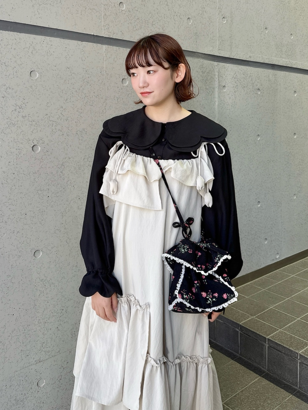 ベージュ系のワンピース、ブラック系のシャツ/ブラウス、ブラック系のショルダーバッグを着用したレディースの冬コーディネートの3枚目の写真